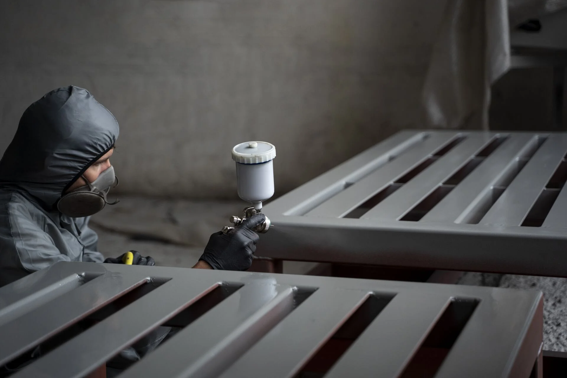 side-view-man-spraying-powder-paint-from-gun